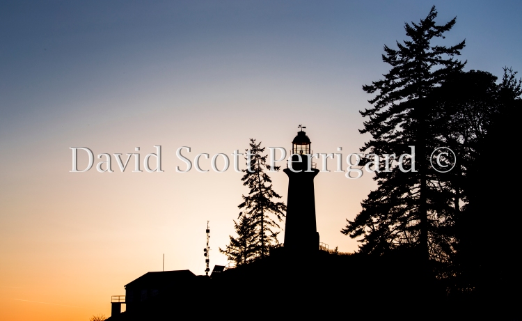 Sun going down behind the lighthouse in Lighthouse Park, West Vancouver, BC.